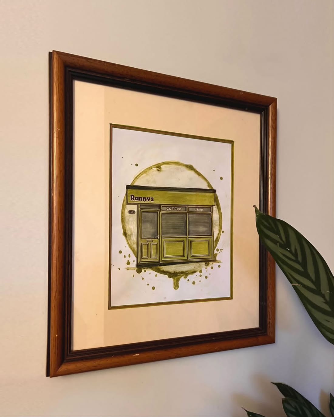 Framed watercolour of the Ranny's shopfront by local artist Sketch Stockport, hung on the shop wall